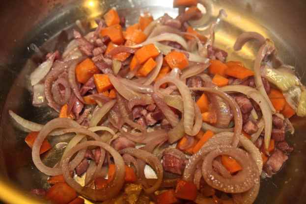 rosolare in una padella antiaderente le cipolle con la pancetta e le carote